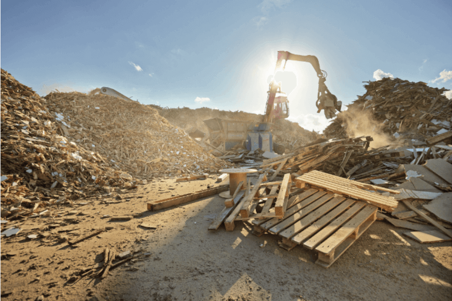 Nachhaltige Holzverwertung bei Frank Schranksysteme – für Umwelt & Qualität Bagger verarbeitet Holzreste auf Recyclinghof – nachhaltige Nutzung bei Frank Schranksysteme für geprüfte Qualität