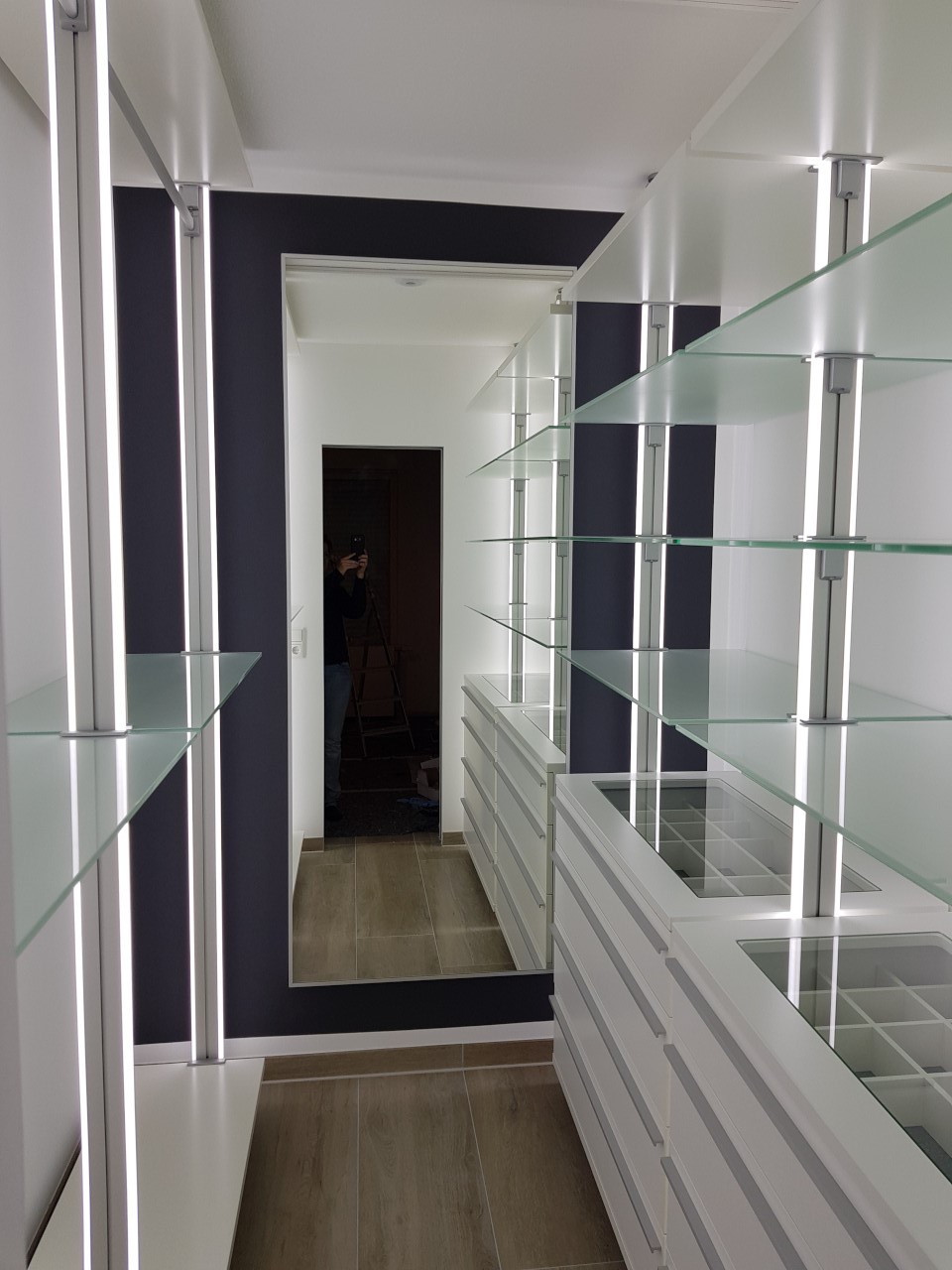 Begehbarer Kleiderschrank mit Multirolli, Glasregalen und LED Beleuchtung Kundenbeispiel: Luxuriöser begehbarer Kleiderschrank mit Glasregalen, Multirolli und integrierter LED-Beleuchtung.